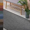 A gray runner rug in front of a bench and a potted plant. Anteprima dell’immagine prodotto