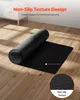A black yoga mat is partially unrolled on a wooden floor, with a close-up inset showing the mat's texture. Podgląd zdjęcia produktu