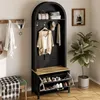 A hallway or entryway with a black arched hall tree featuring a shoe rack, hooks, and shelves, along with a green bench and a potted plant. Produktbild-Vorschau