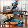 A collage of two images showing a man performing exercises at home, one doing lunges with a couch and the other doing chest presses with a dumbbell. Text overlays the bottom image. Podgląd zdjęcia produktu
