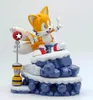 A figurine of the character Tails from Sonic the Hedgehog, sitting on a snowy, rocky base with a signpost. Podgląd zdjęcia produktu