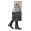A person is holding a black handbag. Náhled obrázku produktu