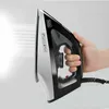 A hand holding a Black+Decker steam iron, with steam coming out of the soleplate. Produktbild-Vorschau