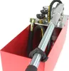 A close-up view of a red hydraulic pressure testing pump with a silver handle and black hoses. Náhľad obrázku produktu