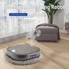 A robot vacuum cleaner is shown on a wooden floor in a modern living room, with a plush ottoman and a large plant in the background. Steam is emanating from the robot, suggesting it is mopping. Produktbild-Vorschau