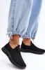 A close-up shot of a person's feet wearing black slip-on sneakers and light blue jeans. Náhľad obrázku produktu