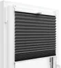A close-up view of a dark gray pleated blind installed in a white window frame. Podgląd zdjęcia produktu