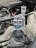 A close-up of a coolant tester inserted into a car's radiator cap, with the engine visible in the background. Anteprima dell’immagine prodotto