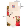 A flat lay of a FC Bayern München themed duvet cover and pillowcase set, featuring cartoon bears playing soccer. Dimensions are indicated with measurement lines and text. Podgląd zdjęcia produktu