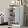 A white shoe cabinet with two doors, filled with shoes and a lamp on top. Produktbild-Vorschau