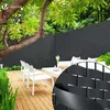 A patio scene with a wooden deck, white outdoor furniture, and a black privacy screen. Produktbild-Vorschau