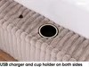 Close-up view of a beige corduroy upholstered bed frame, showing a built-in cup holder and a USB charging port. Produktbild-Vorschau