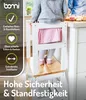 A child stands on a learning tower in a kitchen, reaching for items on the counter. Produktbild-Vorschau