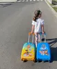 A young girl is walking on a street, pulling two Paw Patrol suitcases. Náhľad obrázku produktu