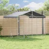 An outdoor dog kennel with a roof, set up on a grassy lawn in front of a wooden fence. Voir les images du produit