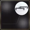 Two black cabinet handles are shown inside a white circle against a black background with a gold border. Voir les images du produit