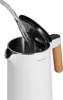 Water being poured into a white electric kettle with a wooden handle. Produktbild-Vorschau