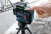 A hand is pressing a button on a Bosch laser level mounted on a tripod. Náhľad obrázku produktu