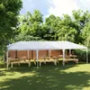 A white party tent set up in a grassy backyard with picnic tables and benches underneath. Produktbild-Vorschau