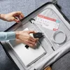 A person is packing a suitcase with electronic devices and travel documents. Anteprima dell’immagine prodotto