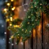 A close-up of a Christmas garland with lights on a wooden surface. Anteprima dell’immagine prodotto