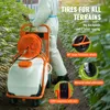 A person in protective gear is pushing a wheeled sprayer through a field. Produktbild-Vorschau