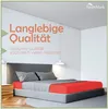 A bedroom scene with a bed featuring red and gray bedding, and text overlays. Produktbild-Vorschau