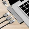 A silver USB hub with multiple USB ports is connected to a laptop, with three USB cables plugged into the hub. Produktbild-Vorschau