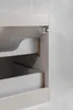 Close-up view of a beige bathroom cabinet with two drawers partially open, showing the interior and drawer slides. Produktbild-Vorschau