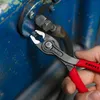 A hand holding a pair of pliers gripping a small bolt against a blue mechanical background. Voir les images du produit