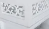Close-up view of a white decorative wooden shelf with carved inserts. Produktbild-Vorschau