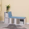 A white storage bench with blue cushions and multiple storage compartments, some filled with books or binders. A vase with white flowers is on top of the bench. Produktbild-Vorschau
