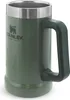 A green Stanley beer mug with a silver rim and a dark green handle, shown from a side angle against a white background. Voir les images du produit