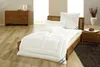 A bedroom scene with a bed, bedding, and furniture. Produktbild-Vorschau