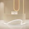 A modern reception desk with curved lines and integrated lighting, set against a neutral background. Produktbild-Vorschau