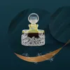 A luxurious perfume bottle with a decorative base, set against a dark teal background with abstract wavy patterns and a golden crescent moon shape with floral accents. Voir les images du produit