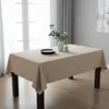 A rectangular table covered with a beige tablecloth, set with black plates and cutlery, and a vase with greenery. Podgląd zdjęcia produktu