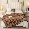 A bed with a brown patterned blanket. Podgląd zdjęcia produktu