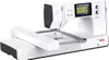 A white and gray bernette b70 DECO sewing machine with an embroidery module attached, shown from a diagonal front-left angle against a white background. Produktbild-Vorschau