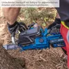 A person wearing gloves is holding a blue and black chainsaw, with a tree trunk in the foreground. Produktbild-Vorschau