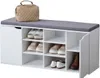 A white shoe cabinet with a gray cushion on top, holding several pairs of shoes and a beige handbag. Náhľad obrázku produktu