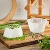 A cheese mold and a formed cheese are displayed on a wooden board, garnished with herbs and spices. Produktbild-Vorschau