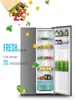 A refrigerator with its door open, showcasing fresh produce and drinks inside, with vegetables falling from a bag above. Produktbild-Vorschau