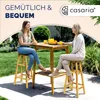 Two women are sitting at a bar table in a garden setting, drinking orange juice. Anteprima dell’immagine prodotto