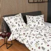 A bed with a duvet cover and pillows featuring a nature-themed print. Produktbild-Vorschau