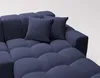 A close-up view of a blue sectional sofa with two throw pillows. Náhled obrázku produktu