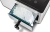 A close-up view of an ice maker's ice drawer, filled with ice cubes and a scoop. Produktbild-Vorschau