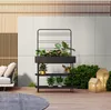 An outdoor patio scene with a planter stand, sofa, and decorative lights. Podgląd zdjęcia produktu