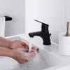Hands washing under a black faucet in a white sink. Produktbild-Vorschau