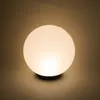 A glowing spherical lamp on a dark base. Produktbild-Vorschau